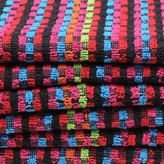 Close-up of colourful blue, green, orange and red tea towel with black background