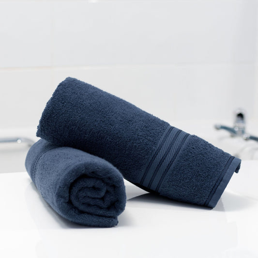Pair of Navy Blue cotton bathroom towels in fine combed cotton on white background