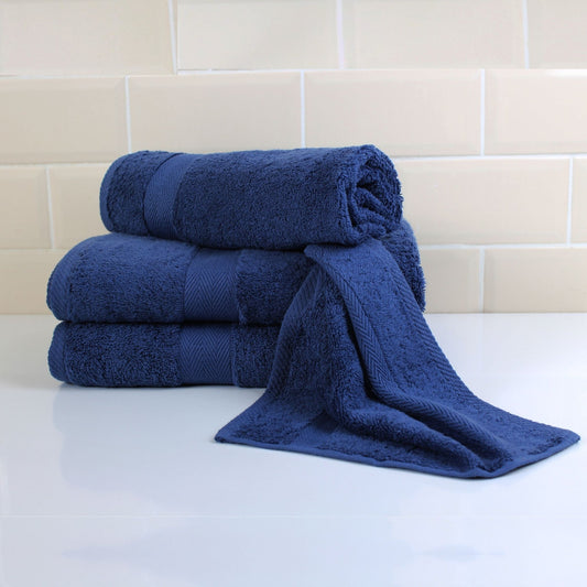 Set of Navy Blue luxury bath towels displayed in luxury bathroom setting, made from fine combed cotton and 600GSM thickness