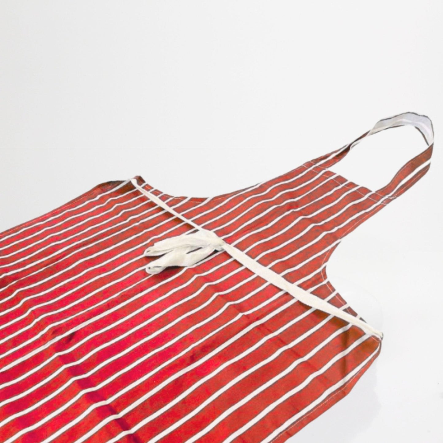 100% cotton, striped red and white chefs apron on white background.