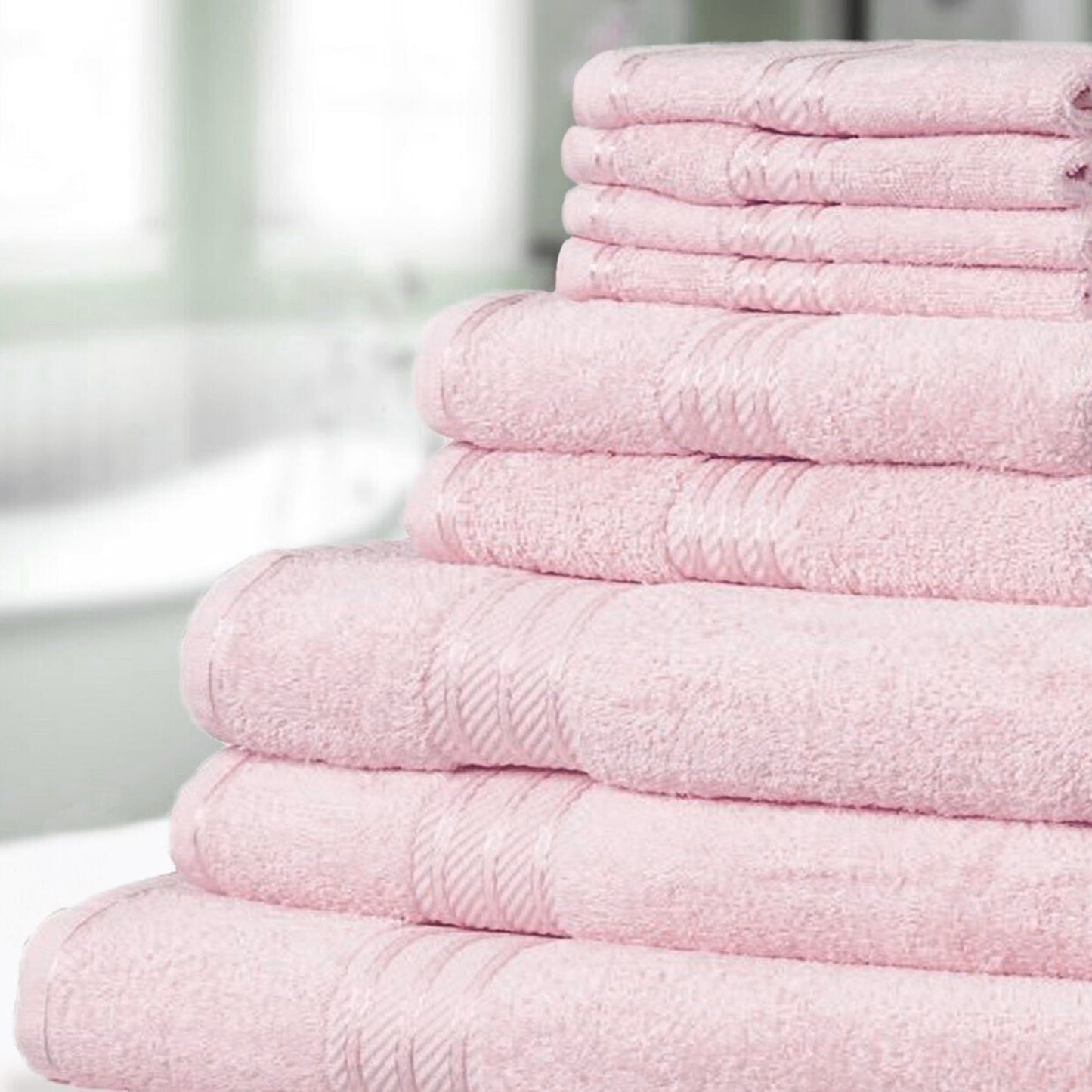 Stack of pastel pink bathroom towels on a blurred background