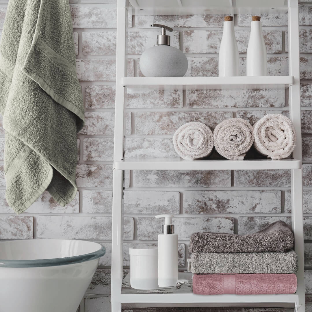 bathroom shelf displaying stack of cotton towels