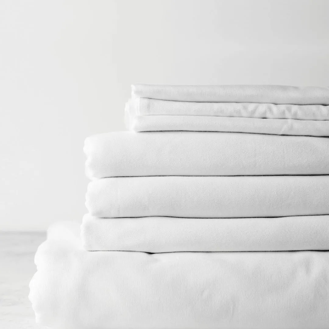 stack of fresh white cotton bedsheets 
