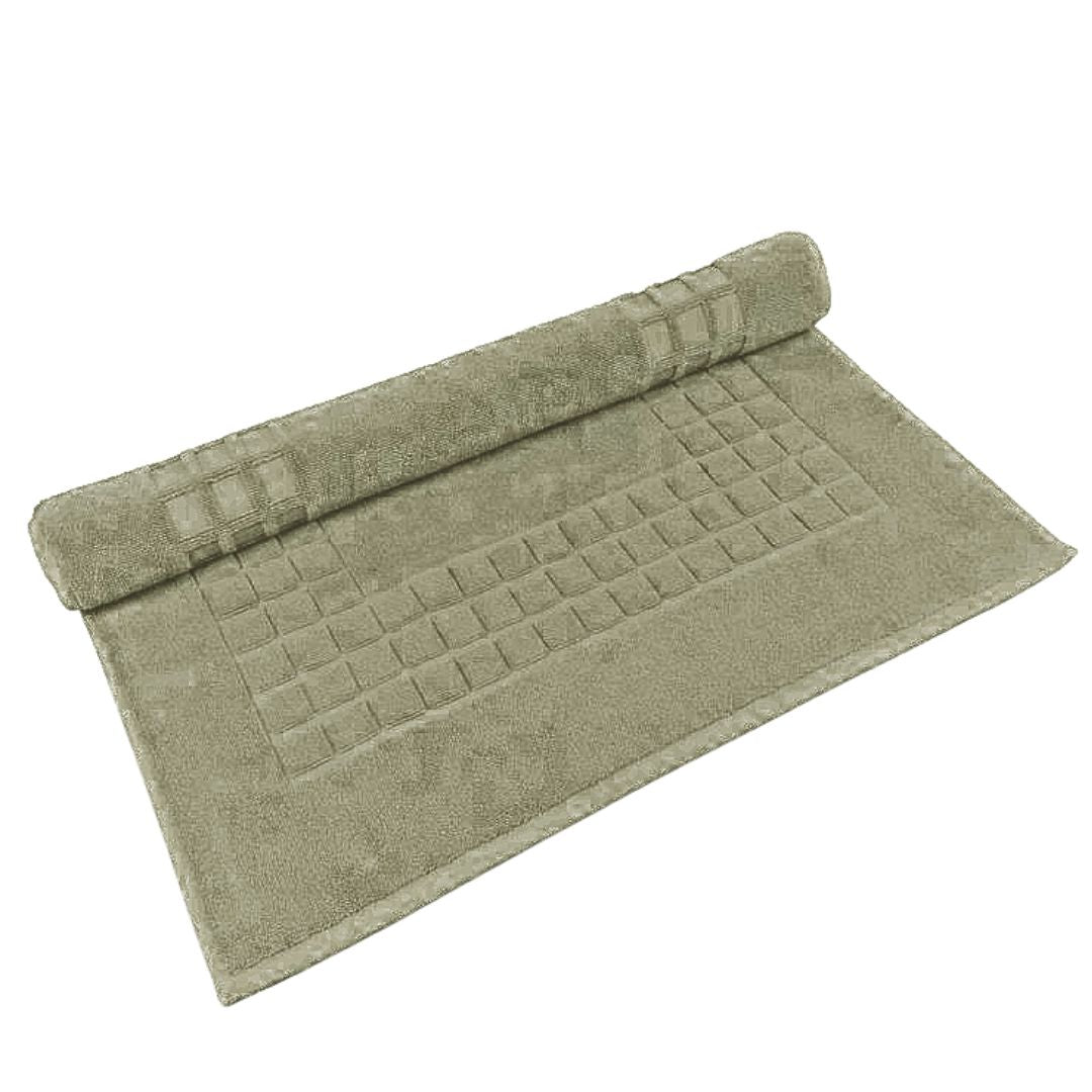 Green bath mat with textured pattern on a white background