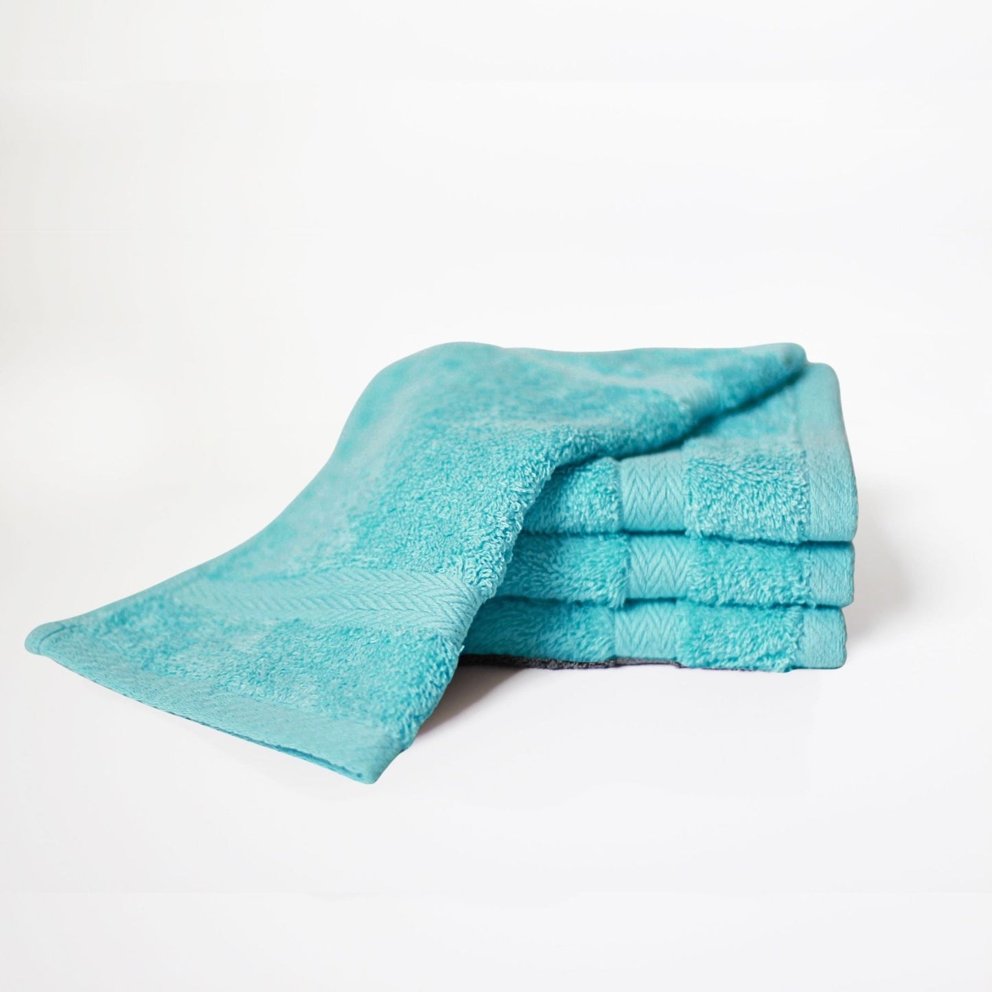 Premium cotton bath towels in Turquoise, made from combed cotton and a thick 600 GSM pile on a white background.