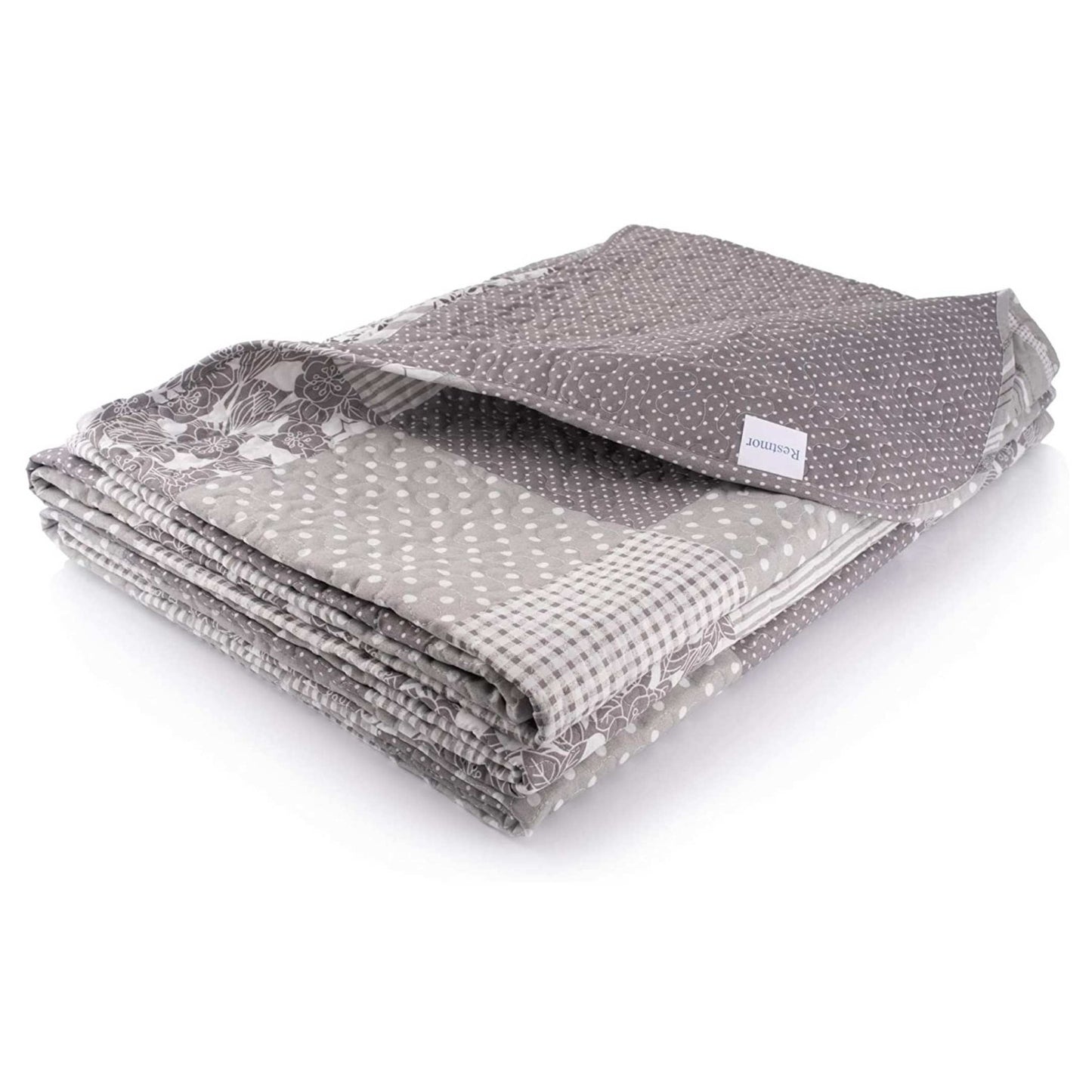 Ariana Bed spread in a patchwork grey and white, floral design on a white background.