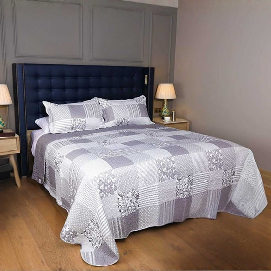 Double bed with a grey and white checkered bed spread in a bedroom setting.