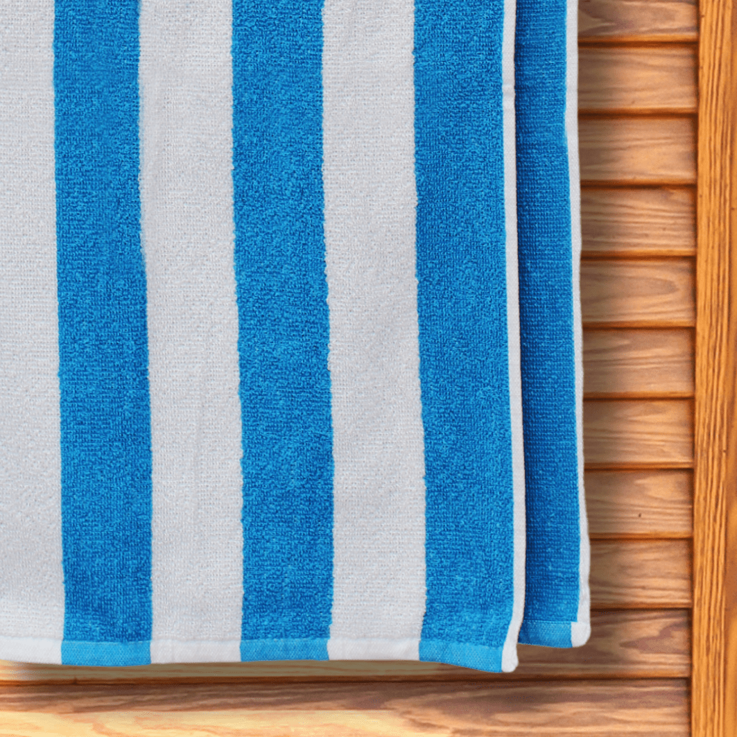 Budget-friendly blue and white striped beach towel hanging on a changing room door.