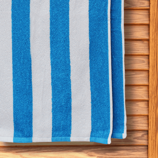 Budget-friendly blue and white striped beach towel hanging on a changing room door.
