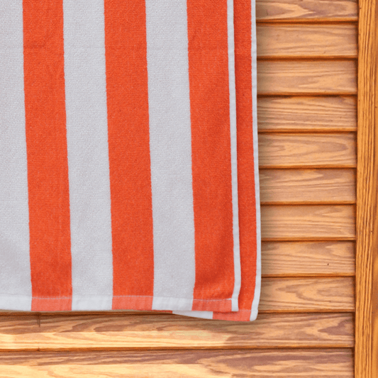 Striped red and white beach towel hanging on a changing room door.
