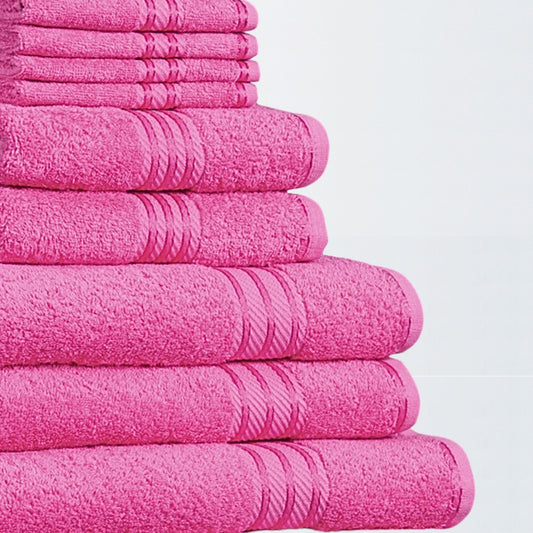 Stack of 500 GSM bathroom towels in bright pink made from fine combed cotton on white background. 