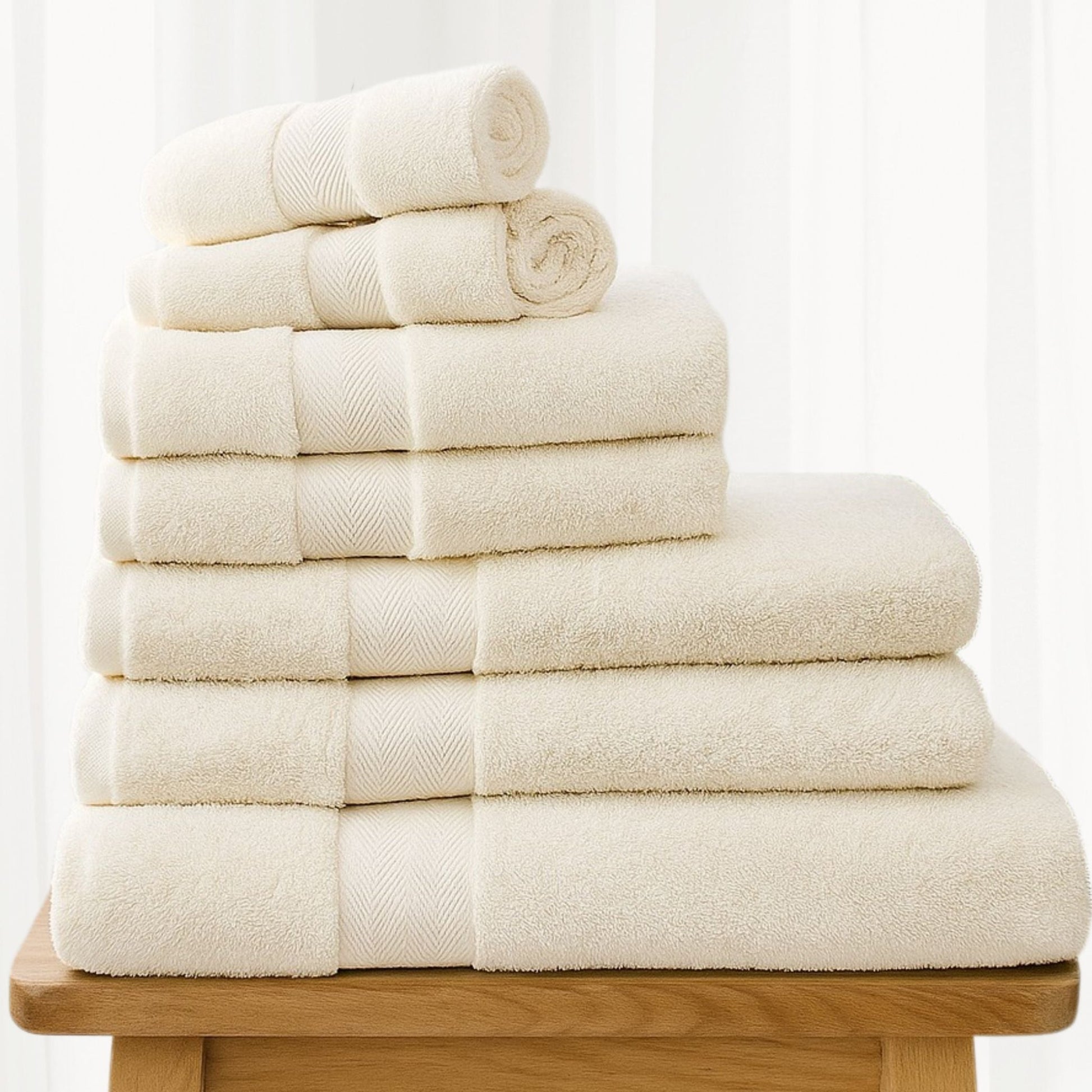 Luxury 600 GSM bathroom towel stack in Ivory, made from fine combed cotton on a white bathroom background.