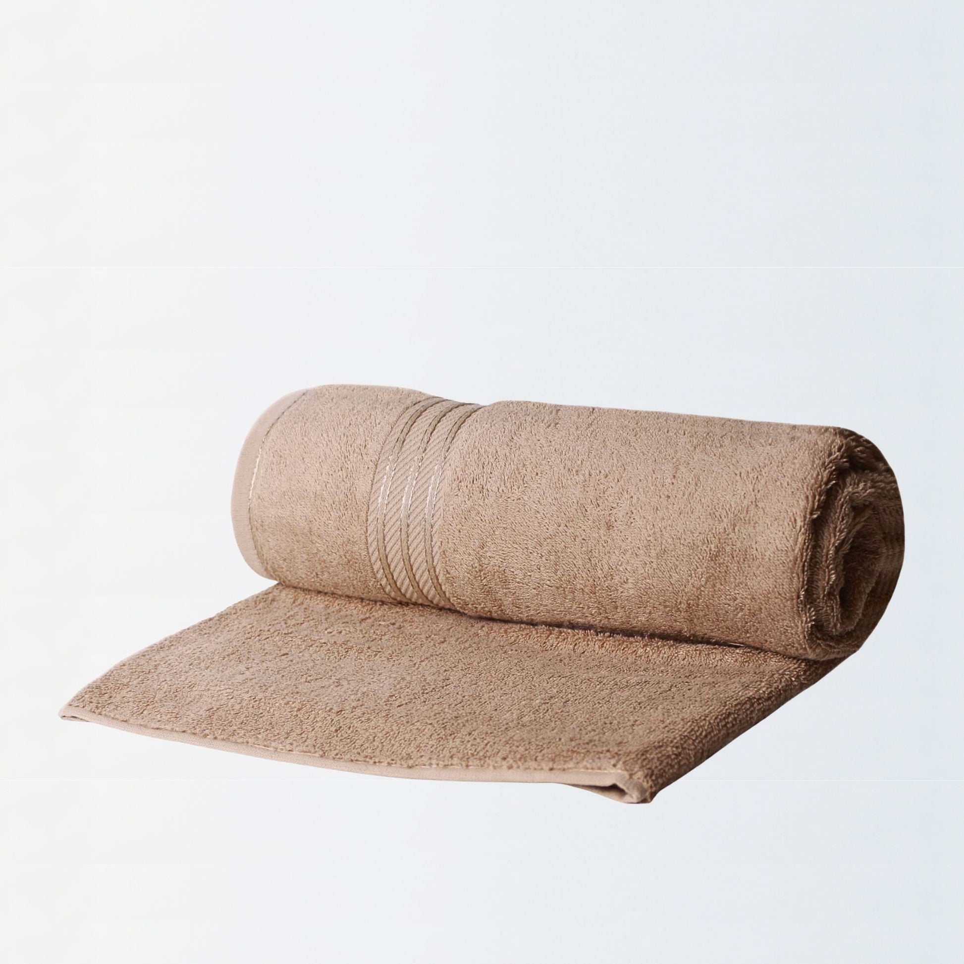 Rolled  600 GSM luxury bath sheet in Latte made from fine combed cotton on white background. 