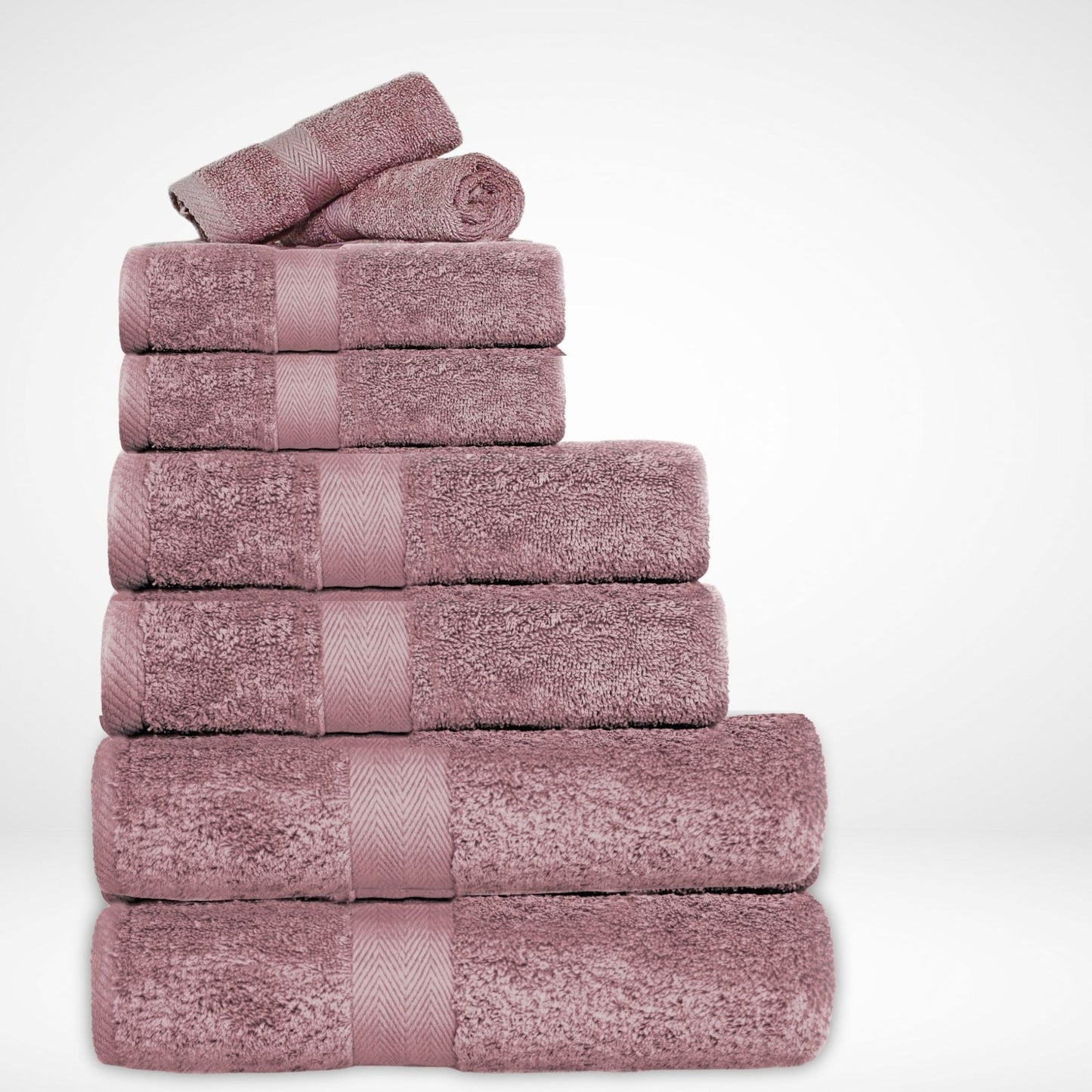 Stack of luxury bathroom towels in Mauve, made from a soft combed cotton and thick 600 GSM pile on a white background.