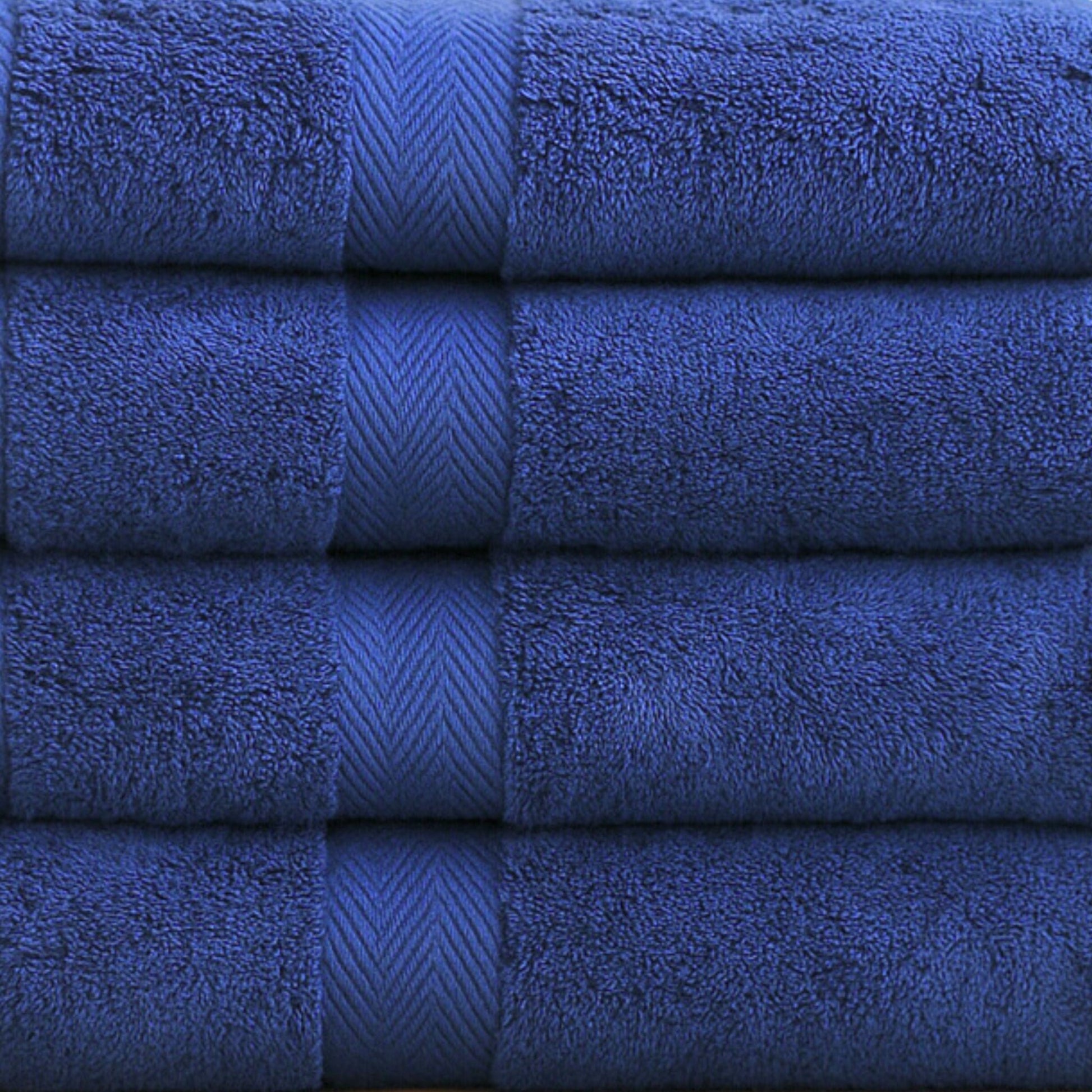 Close up stack of luxury bathroom towels in Navy Blue, made from fine combed cotton with thick 600 GSM pile 