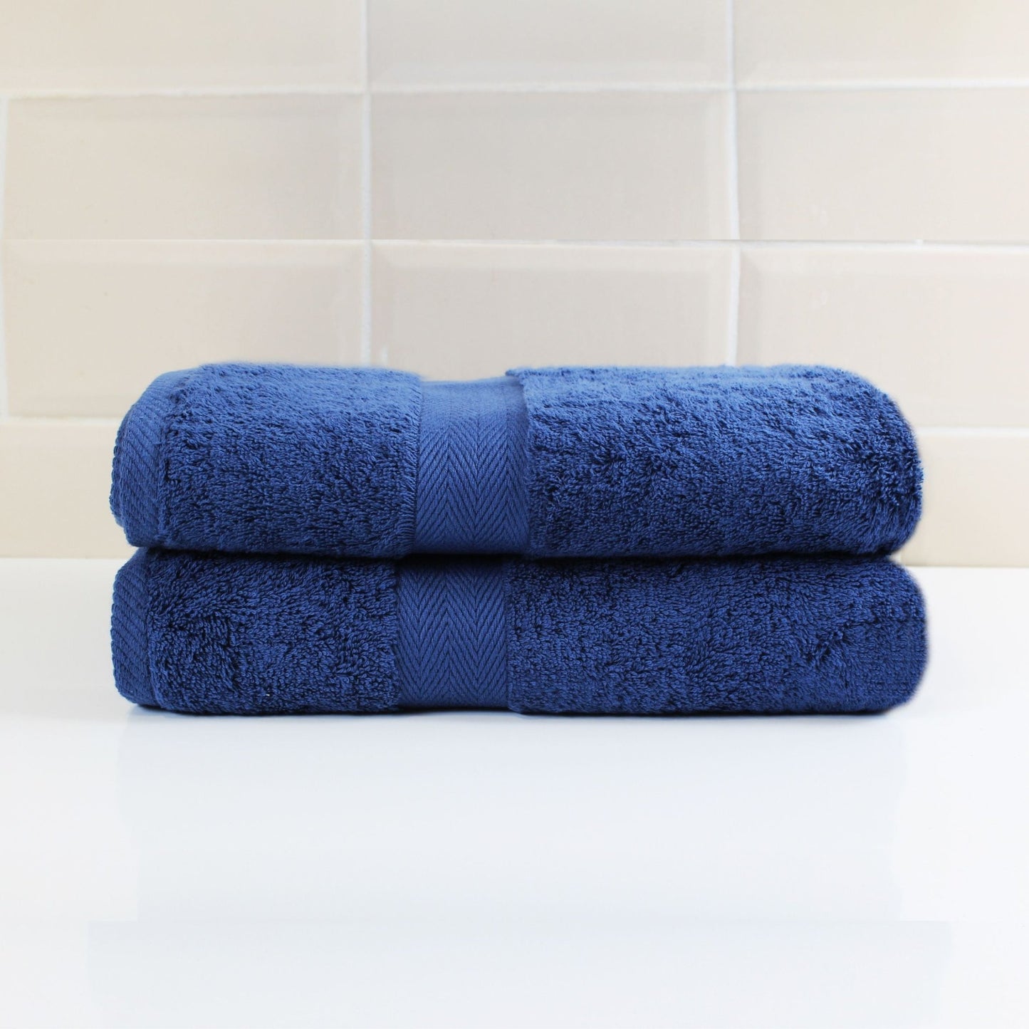 Pair of Navy Blue luxury bath towels in a luxury bathroom setting, made from fine combed cotton and 600 GSM thickness 
