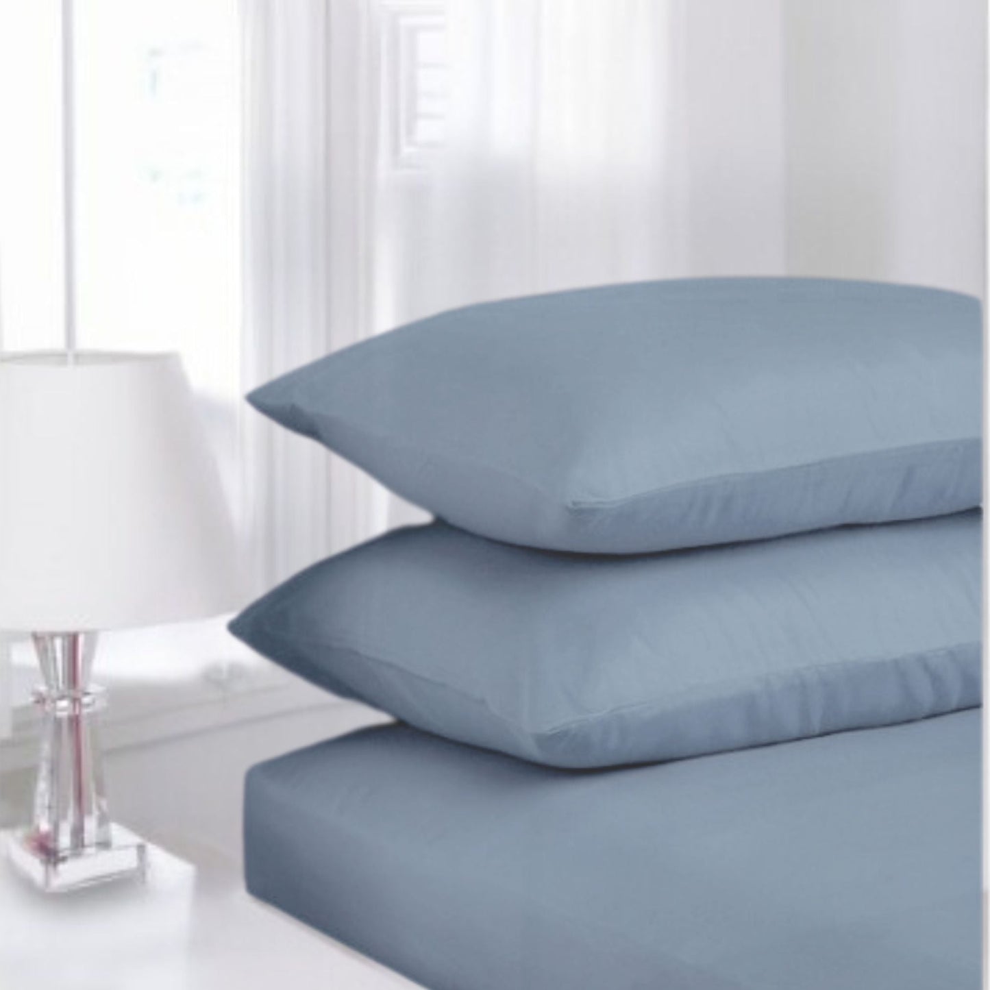Ocean Bluse Percale fitted sheet made from polycotton displayed in a classic white guest room setting