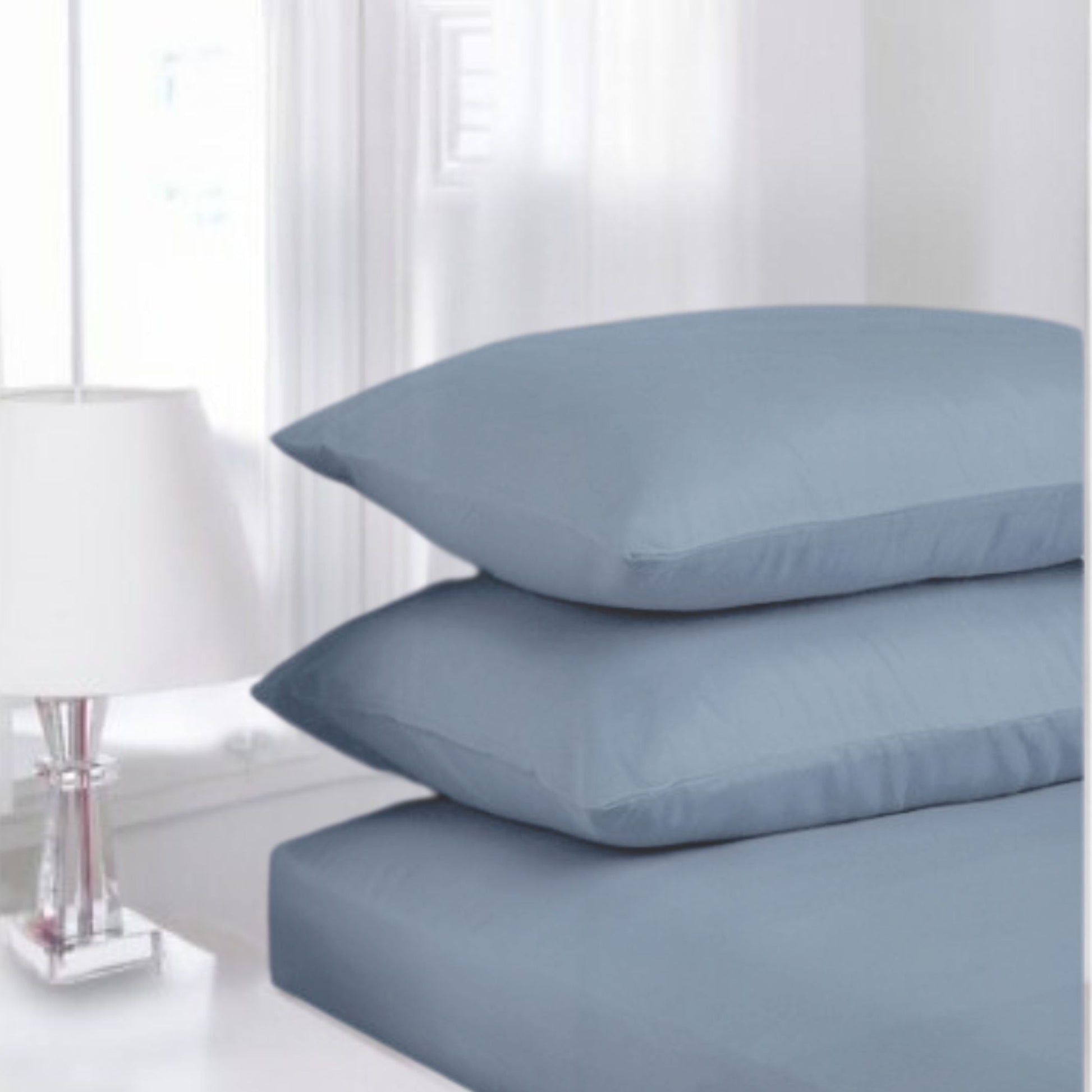 Ocean Bluse Percale fitted sheet made from polycotton displayed in a classic white guest room setting