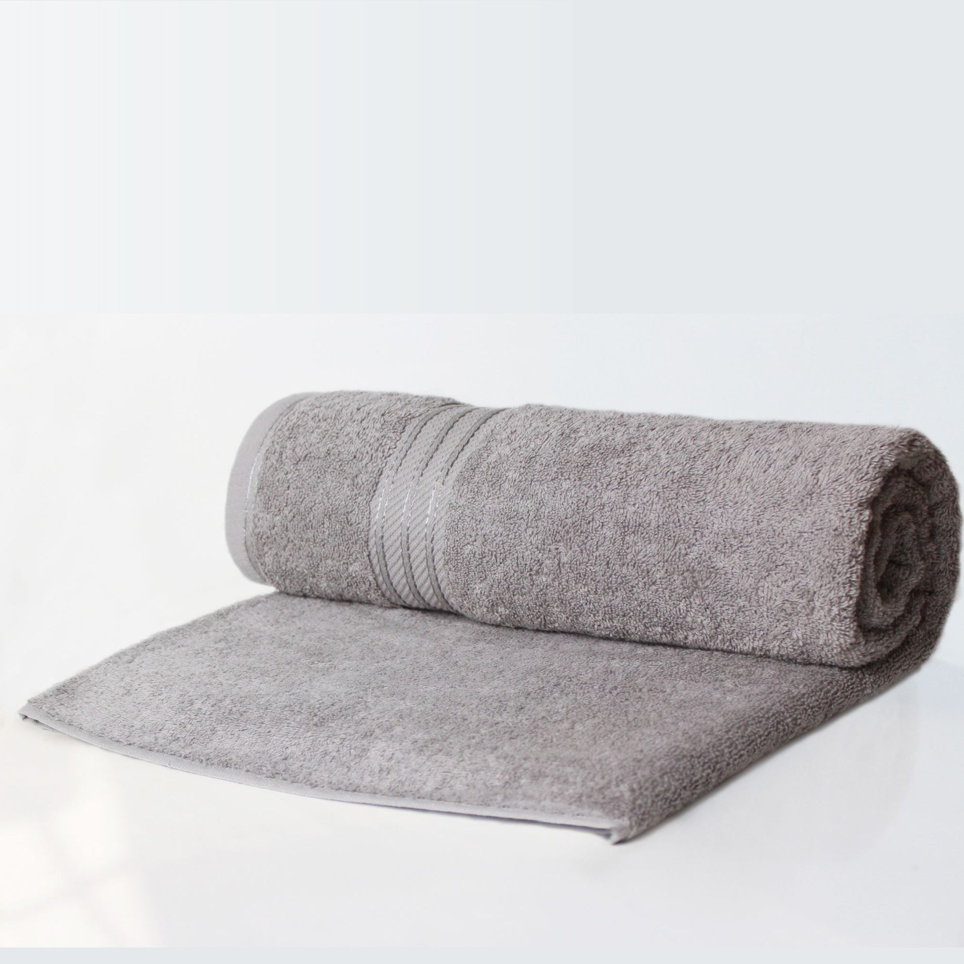 Rolled-up grey bathroom towel on a white background