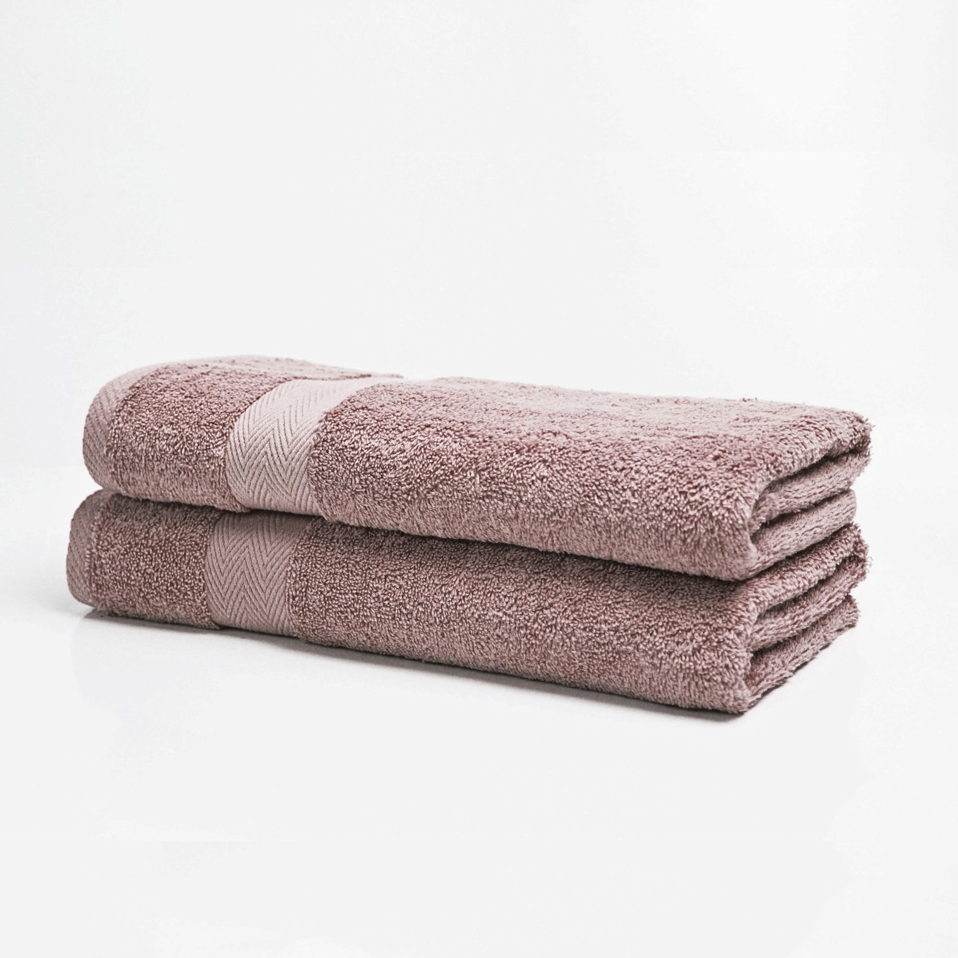 Stack of two folded light purple bath towels on a white background