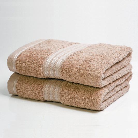 Two folded beige bath towels on a white background