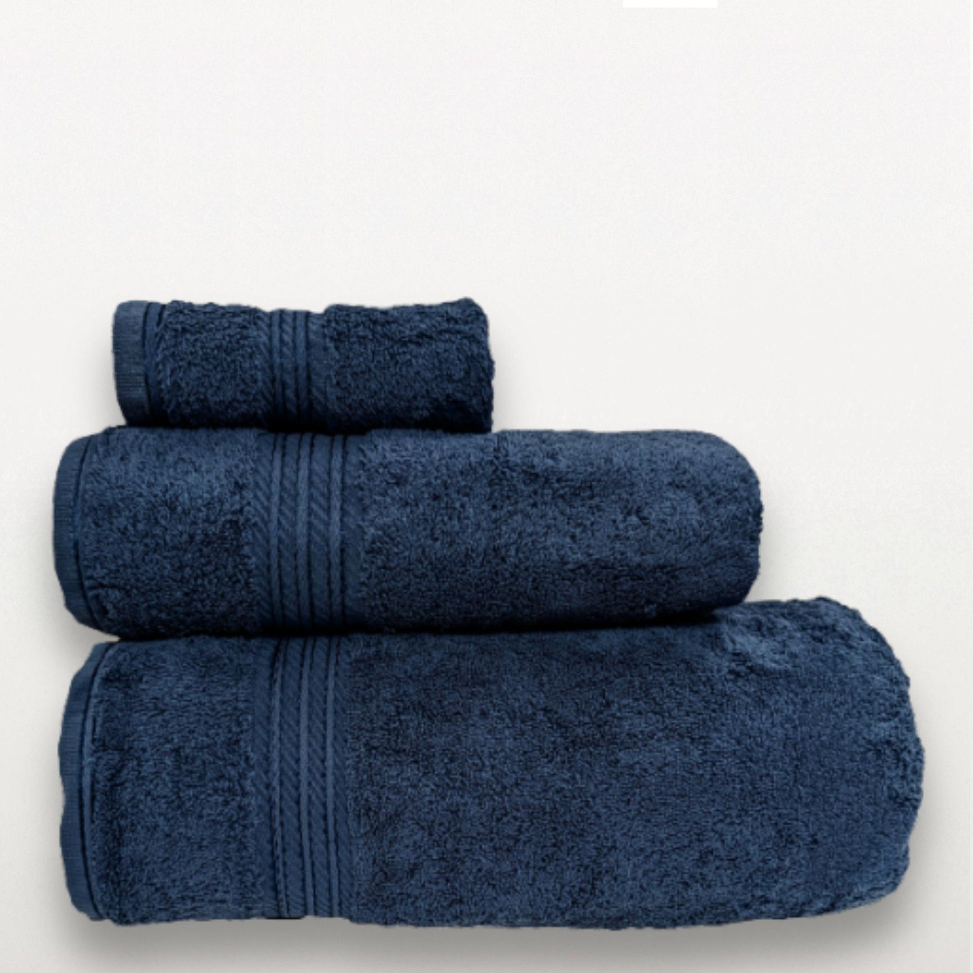 Three blue towels stacked on a white background