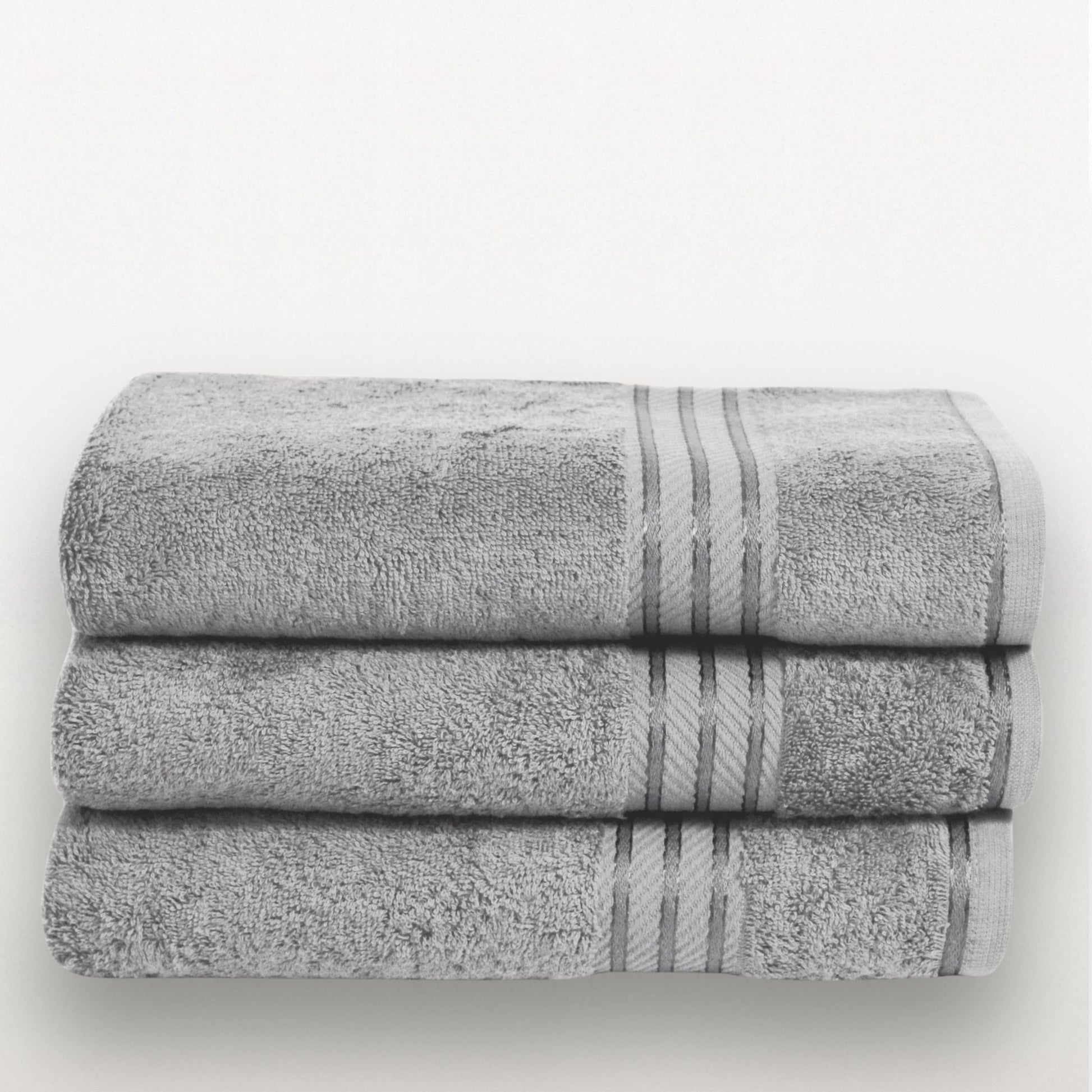 Stack of grey bath towels with satin border on a white background.