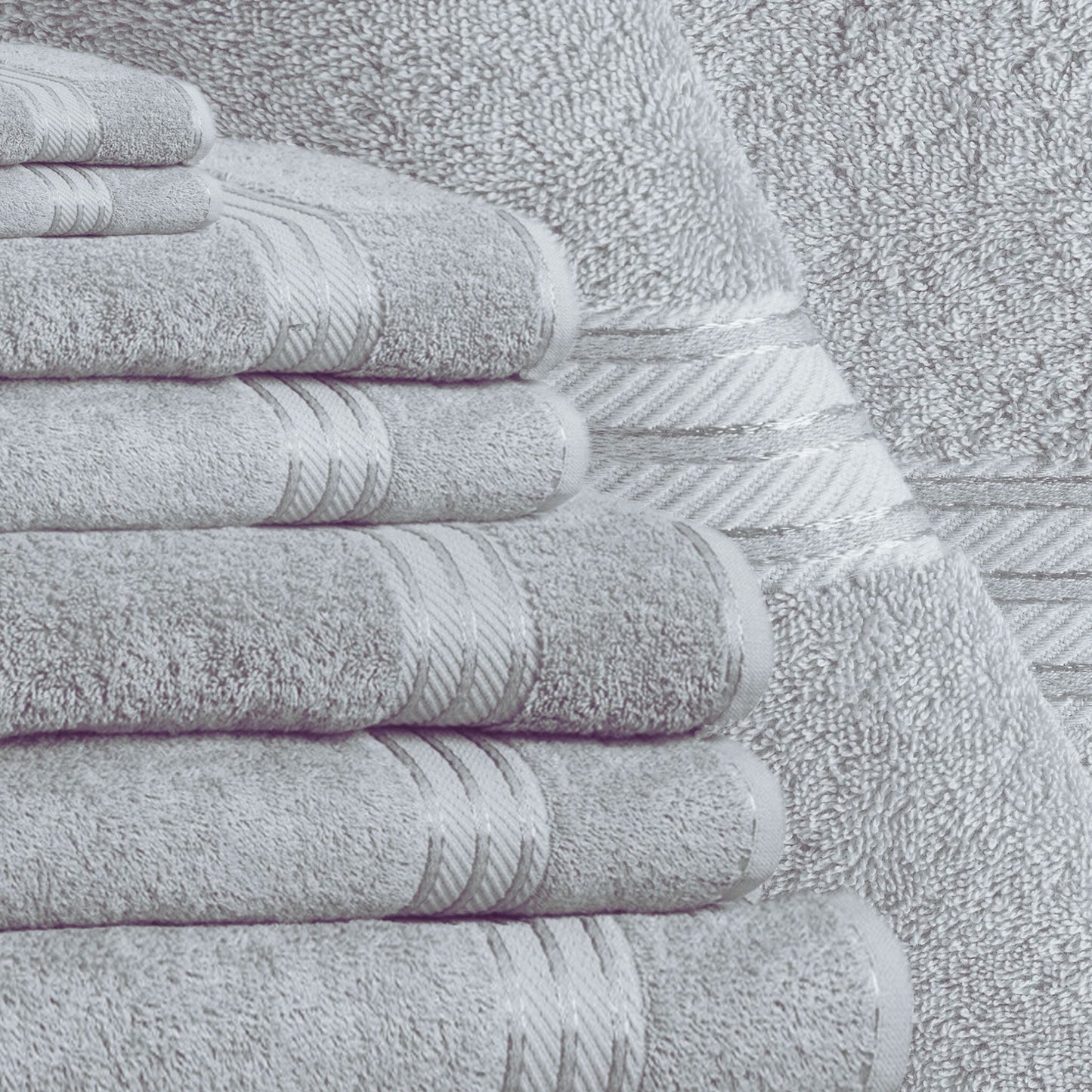 Stack of grey bath towels on a textured surface