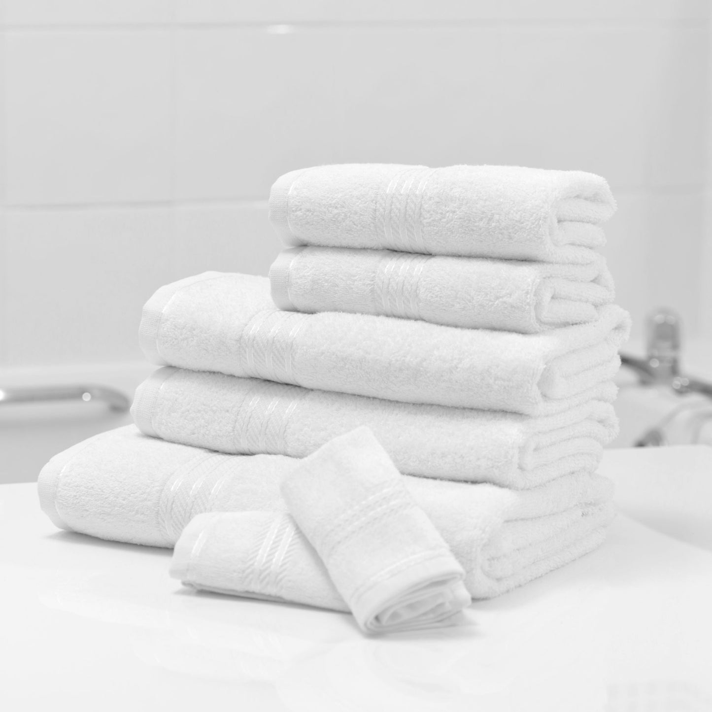 White bathroom towel, combed cotton, 500GSM, folded and stacked, luxury hotel quality.