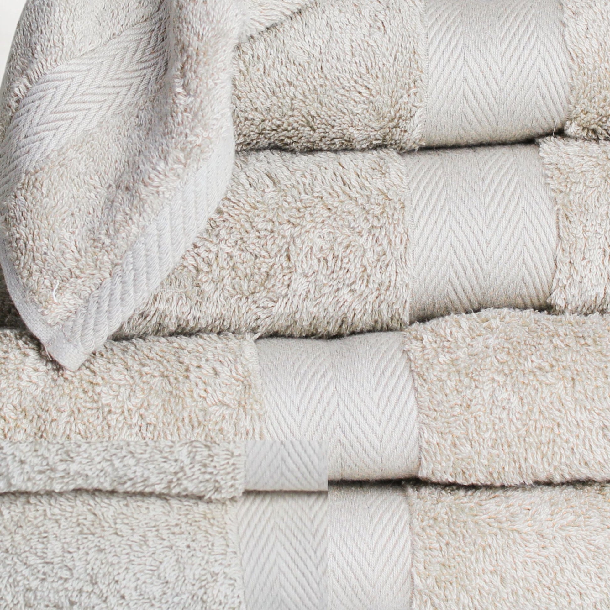 Close up stack of luxury bathroom towel in natural beige, made from fine combed cotton with thick 600 GSM pile