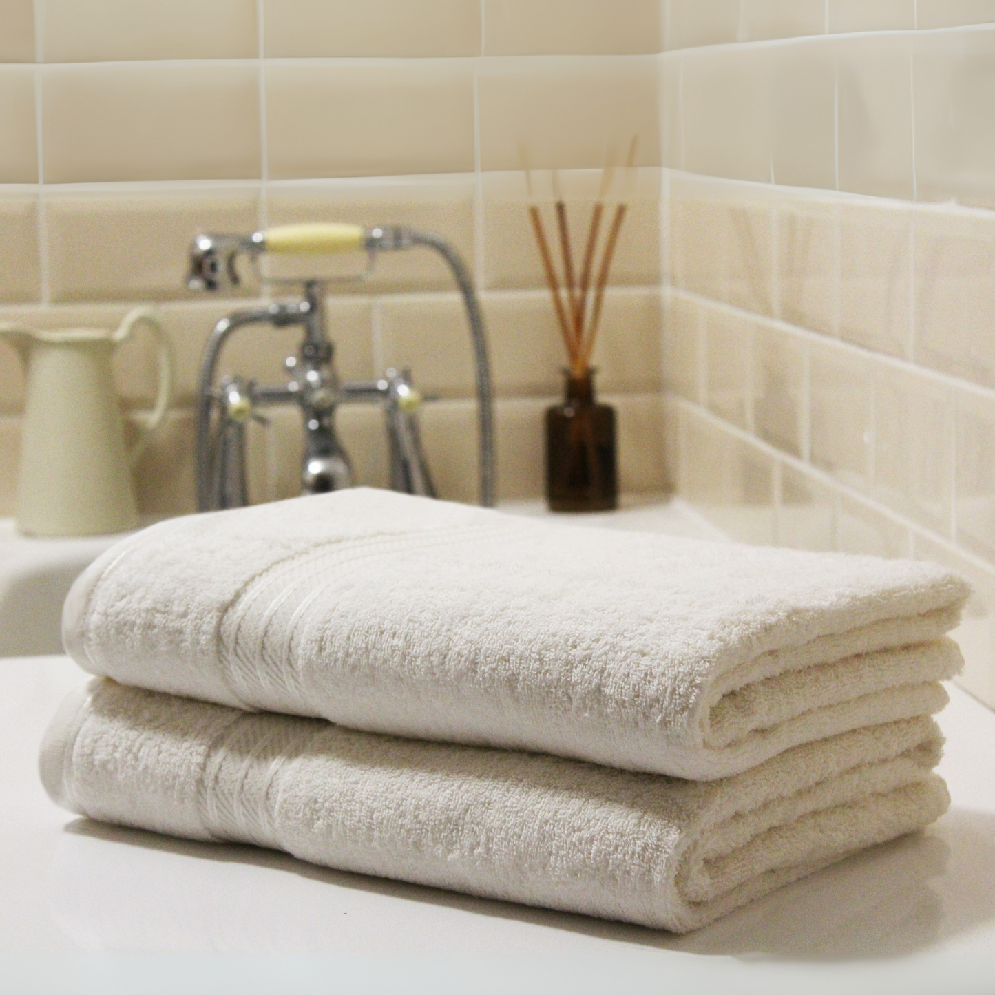 Ivory Egyptian cotton bathroom towel, 500GSM, folded and stacked, luxury hotel quality.