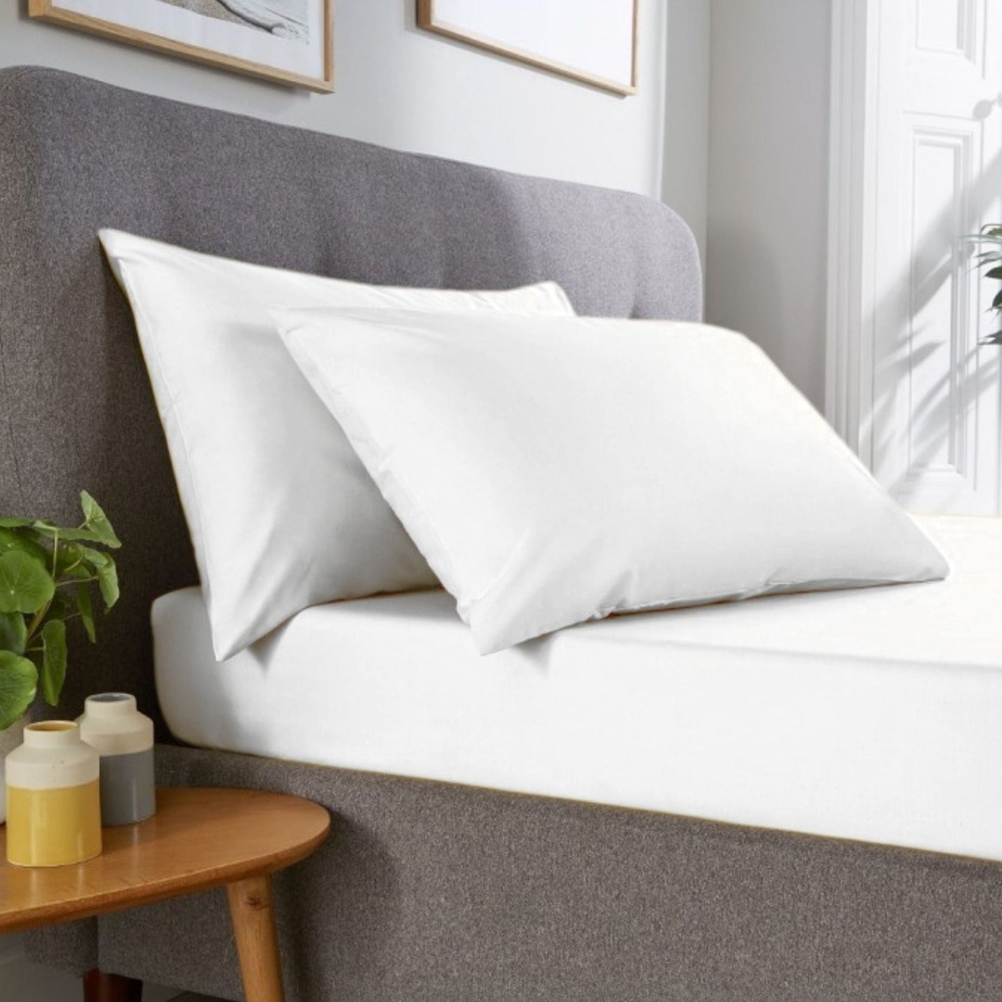 Fresh white Percale pillowcase pair made from a polycotton blend displayed in classic hotel room 